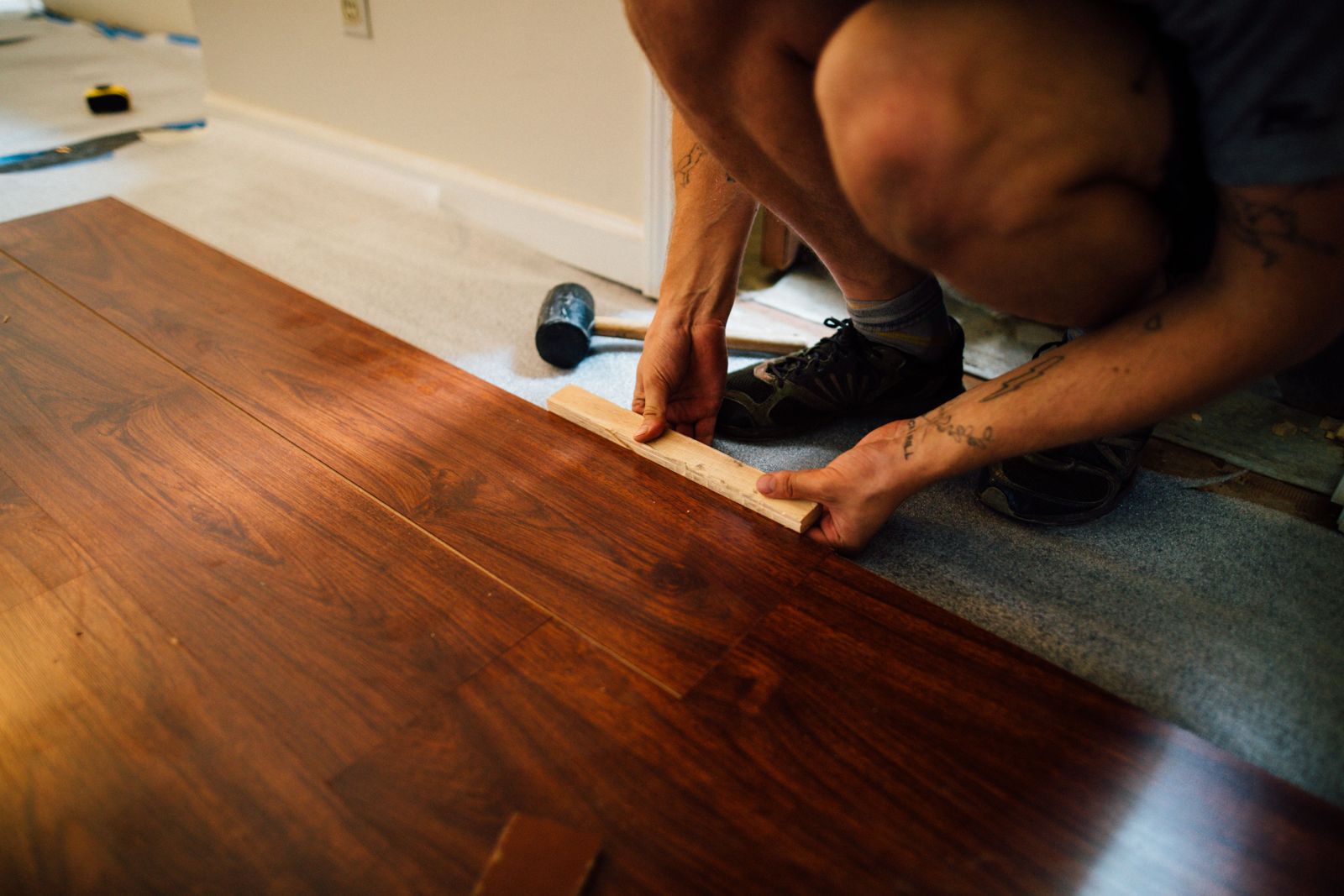 Close-up of a laminate plank being tapped into place