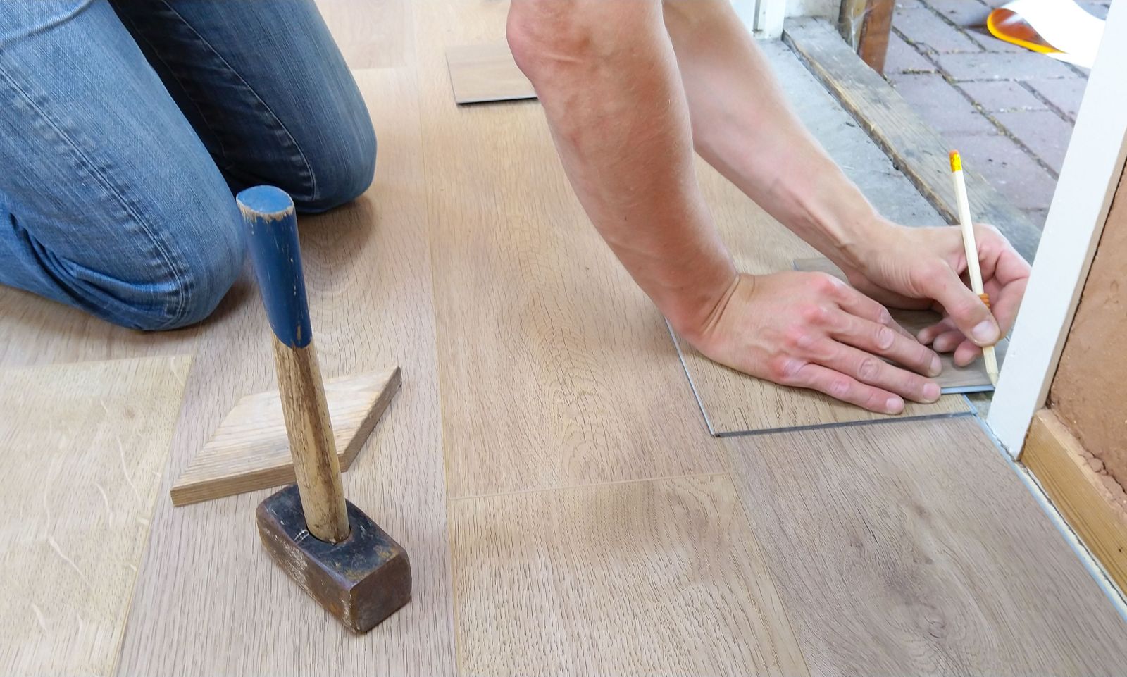 Pencil marking a plank for a cut at a doorway